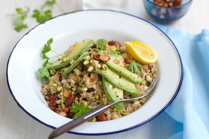 A bowl of brown rice salad with asparagus and avocado