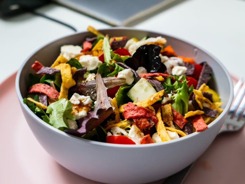 A bowl of mixed salad with leafy greens and chopped vegetables