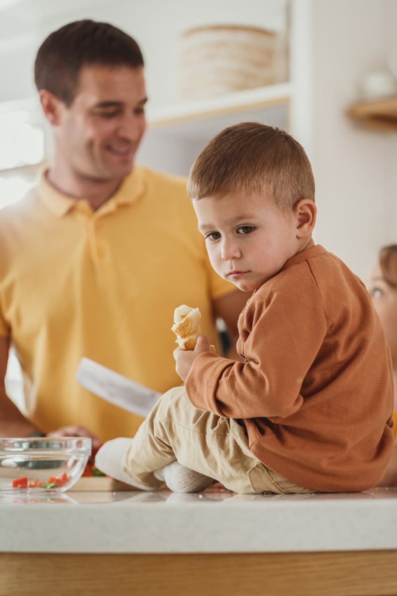A parent and child preparing food together in a home kitchen