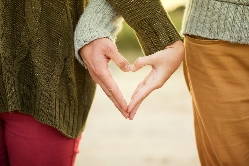 Two people making a heart shape with their hands