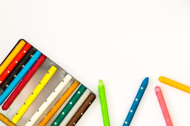 Colourful crayons in a tin and on a white surface