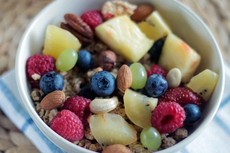 A breakfast bowl with oats, mixed fruit and nuts